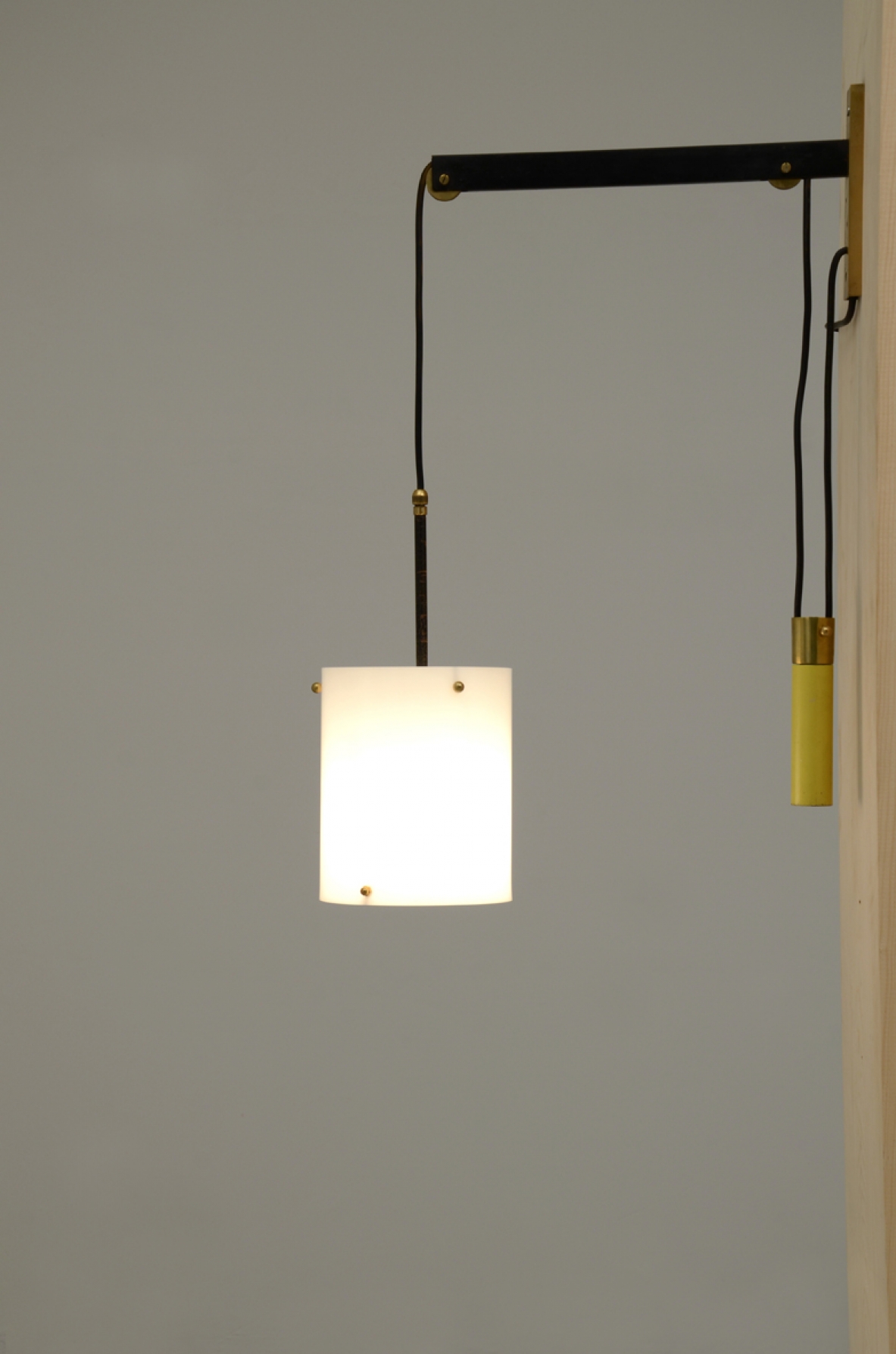 Lampada saliscendi da lettura con peso in ottone laccato giallo e cappello in polipropilene bianco. Francia, 1950 ca.