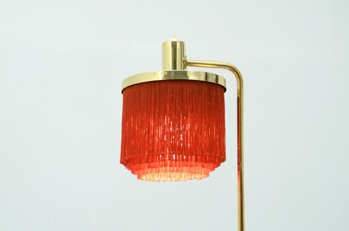 Hans Agne Jacobsson, rara lampada da terra con cappello a fili di seta rossi, stelo e base in ottone, Svezia 1950ca.