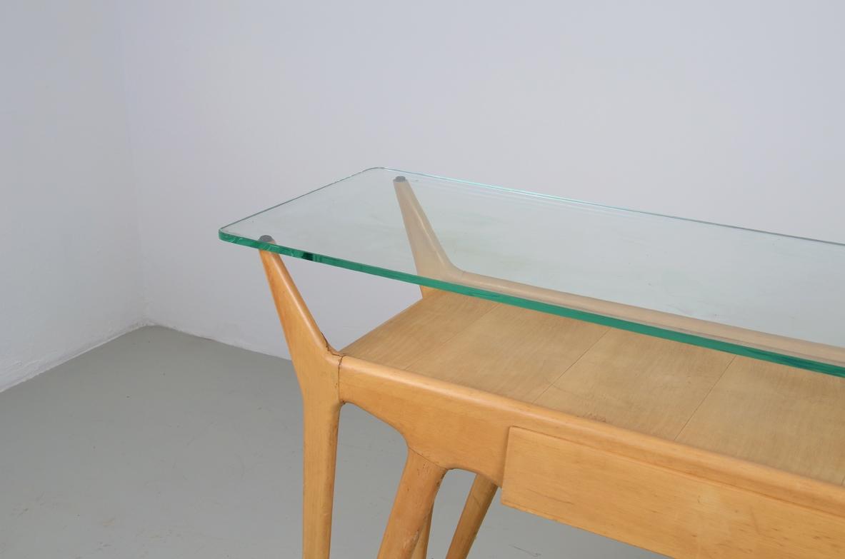 Italian manufacture, console in blond maple with a central drawer and glass top.