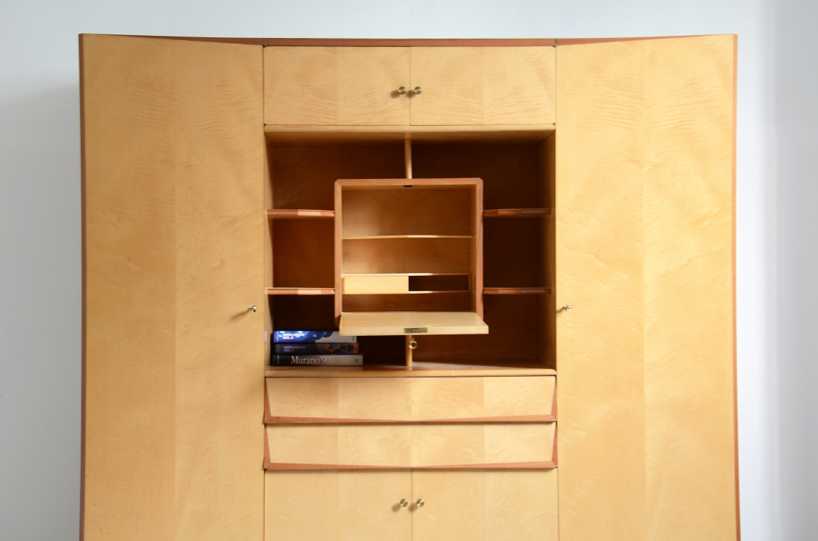 Unique Italian 1960's highboard in light maplewood. Doors and drawers with shelves inside and a very special central open compartment with a folding top hiding small shelves and one drawer.