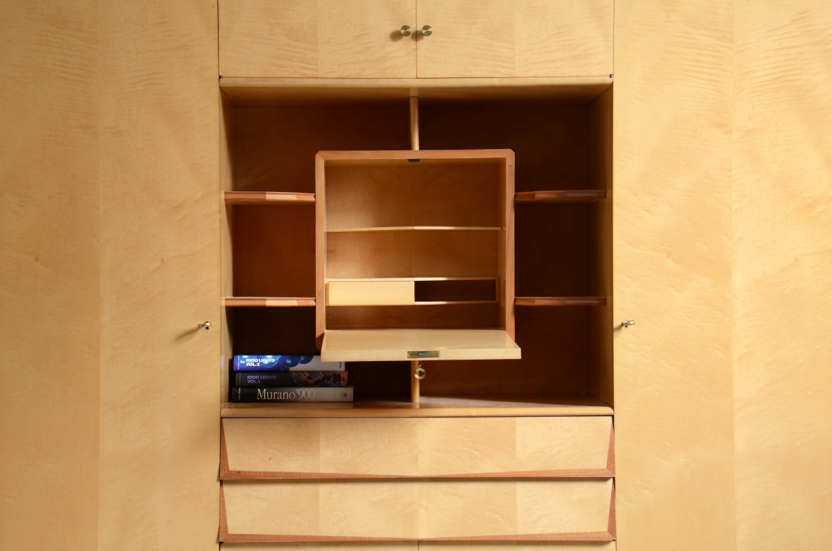 Unique Italian 1960's highboard in light maplewood. Doors and drawers with shelves inside and a very special central open compartment with a folding top hiding small shelves and one drawer.
