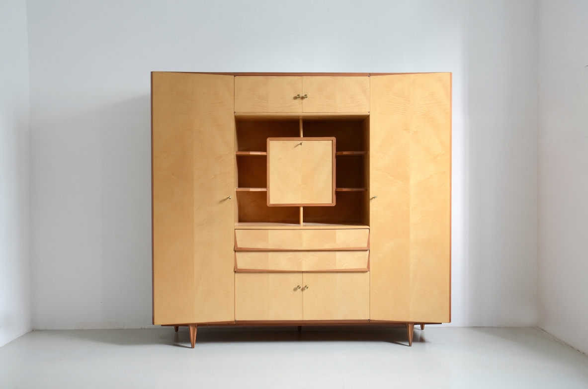 Unique Italian 1960's highboard in light maplewood. Doors and drawers with shelves inside and a very special central open compartment with a folding top hiding small shelves and one drawer.