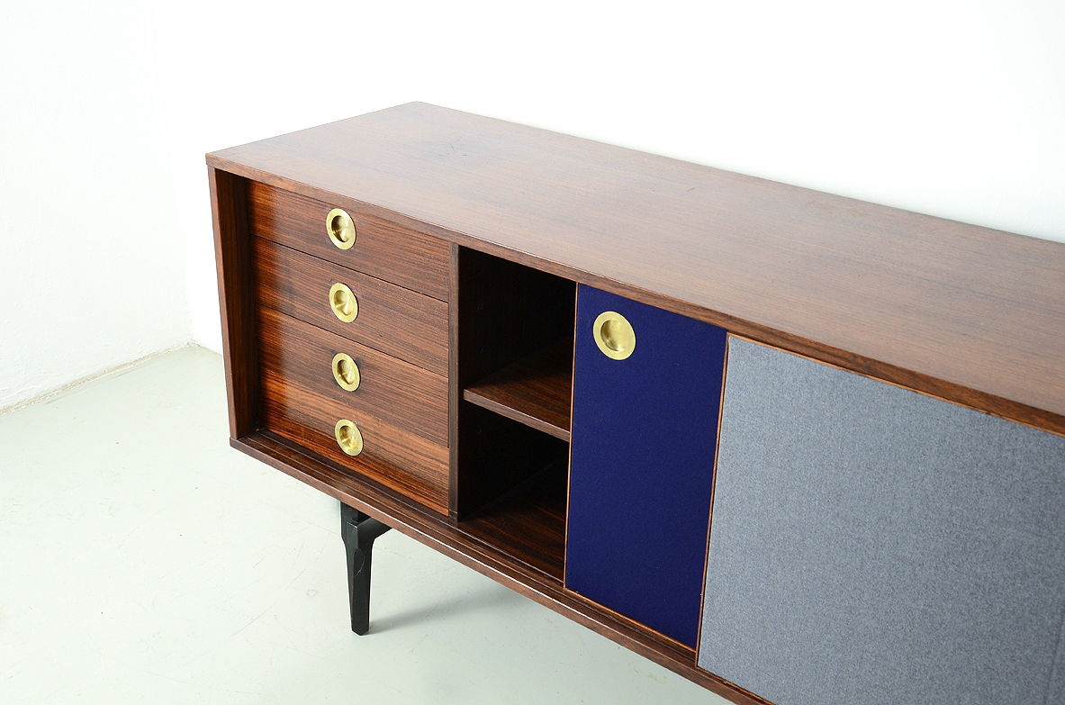 Stildomus, Sideboard in palissandro con due lunghe ante scorrevoli rivestite in panno, all'interno quattro cassetti e ripiani.  Bocchette in ottone, Italia, 1960ca.