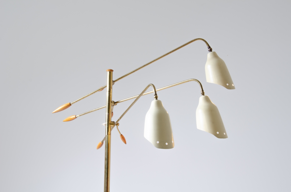 Piantana in ottone a tre bracci regolabili e coni sagomati in metallo verniciato con eleganti finali in legno tornito.  Prod. Arredoluce, 1950ca.