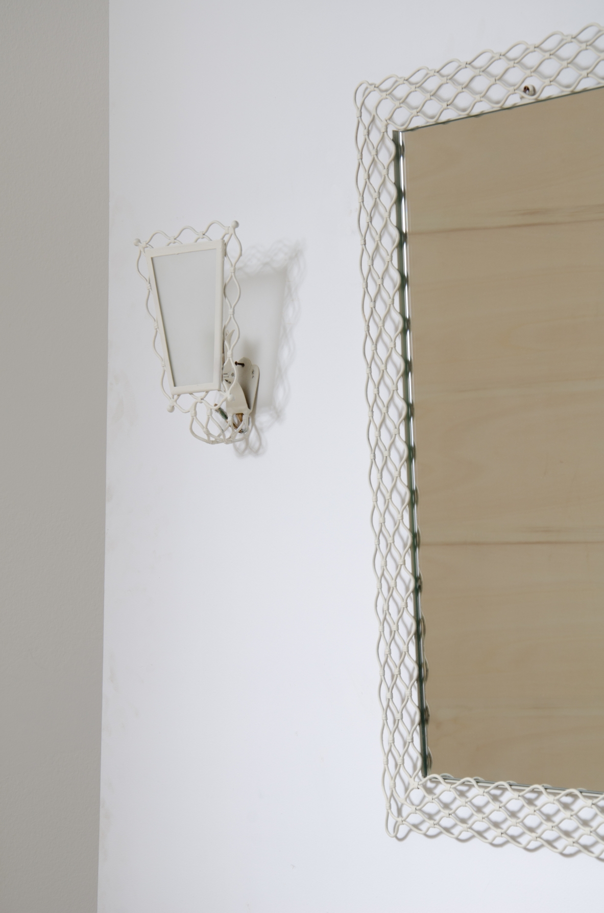 Mirror with curved metal mesh frame with two wall lights of the same workmanship with satin glass.  Italy 1950s.