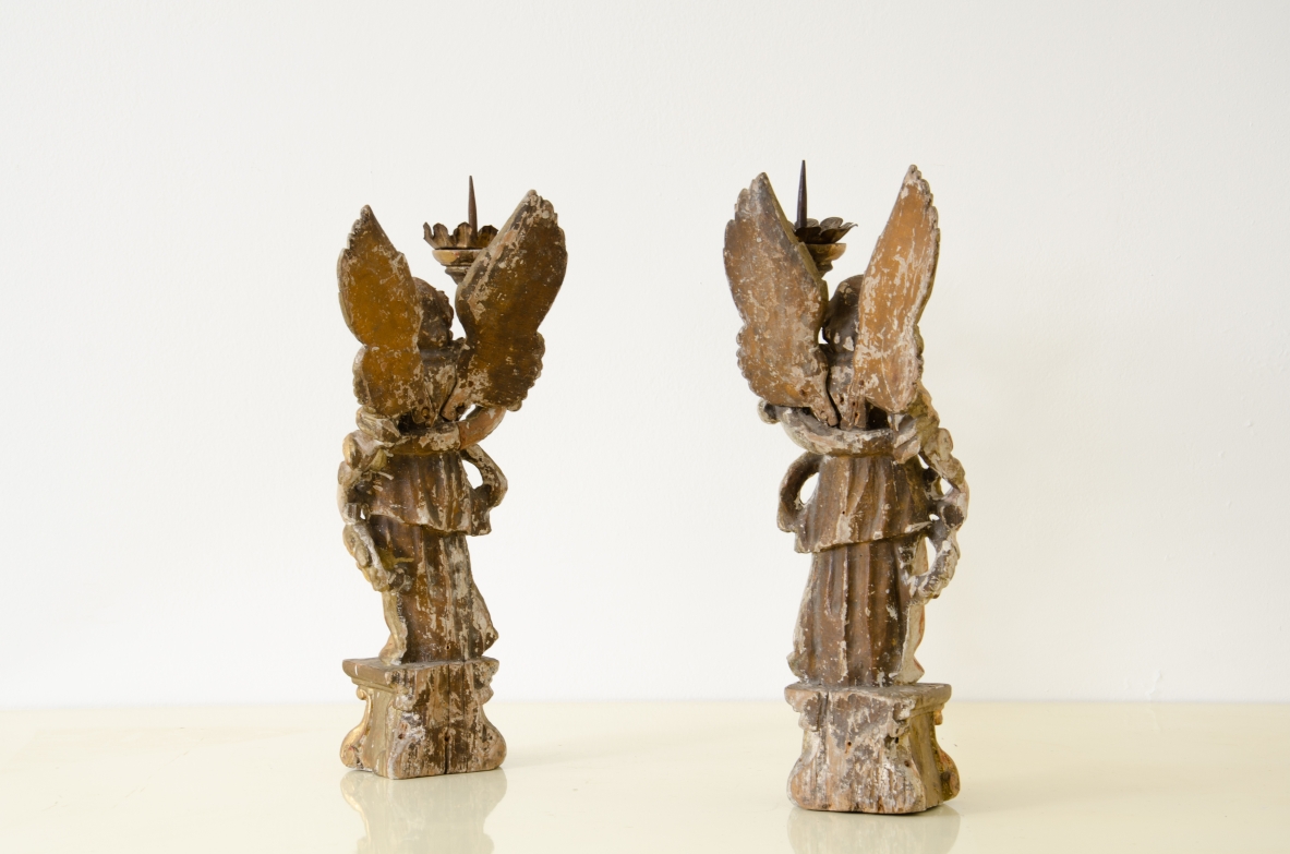 Coppia di angeli in legno laccato e dorato che reggono una cornucopia con corona in metallo dorato.   Italia centrale, epoca Barocco, seconda metà del XVII secolo.