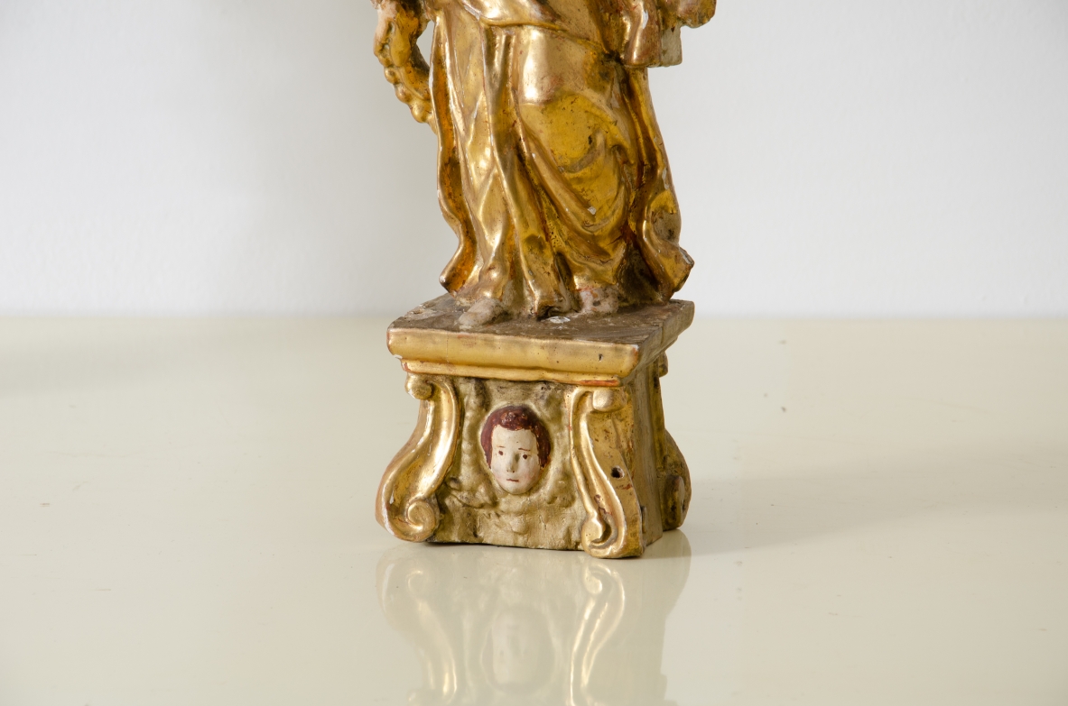 Coppia di angeli in legno laccato e dorato che reggono una cornucopia con corona in metallo dorato.   Italia centrale, epoca Barocco, seconda metà del XVII secolo.