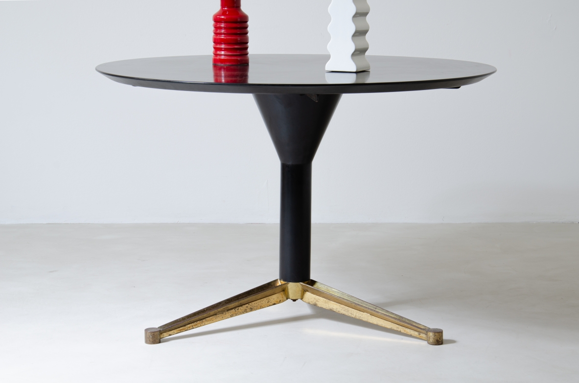Melchiorre Bega, tavolo in legno laccato nero con base a tre razze sagomate in ottone.  Manifattura Bega & C. Bologna anni 50.