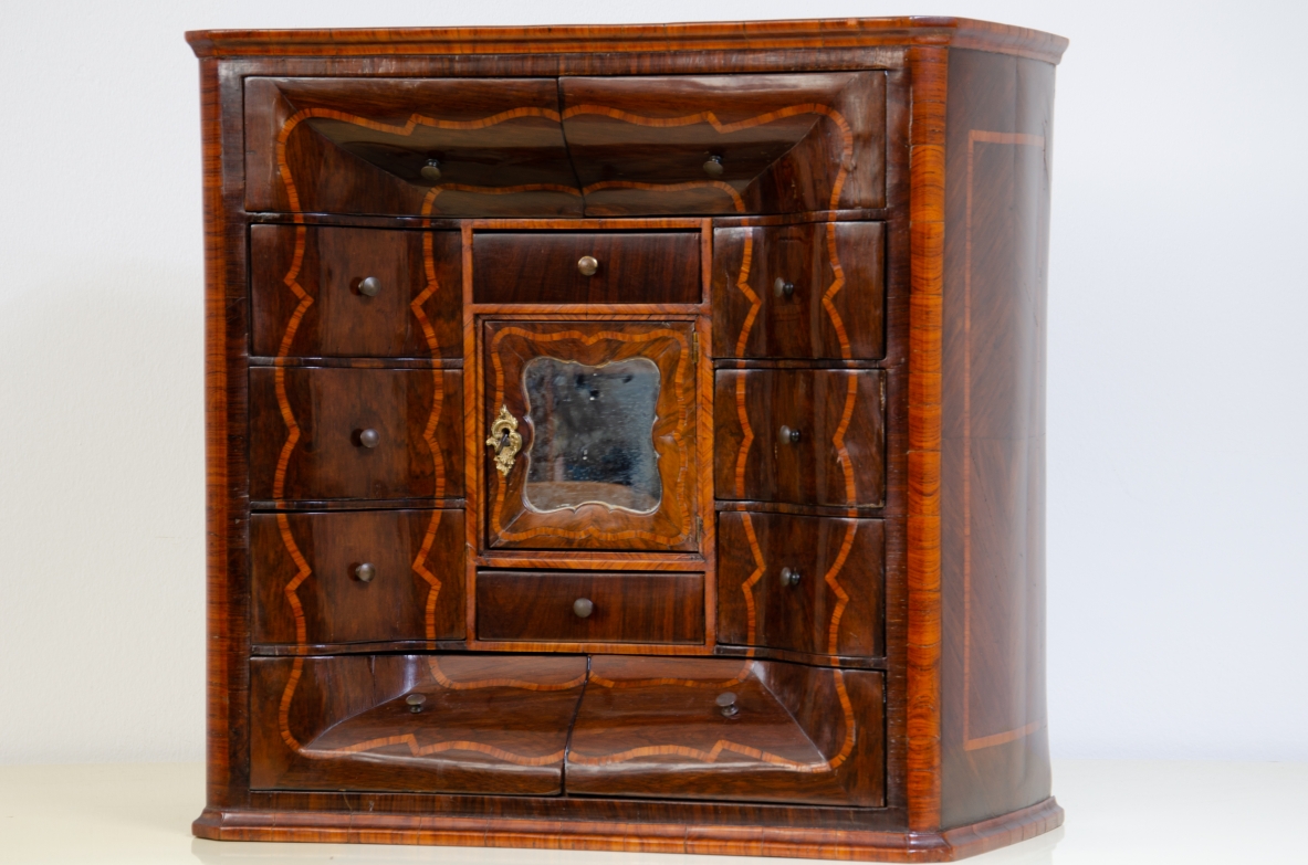 Ebanisteria genovese, 1750ca, monetiere in legno di viola filettato in legno di rosa con fronte mosso, edicola centrale con sportello sagomato e specchio centrale
