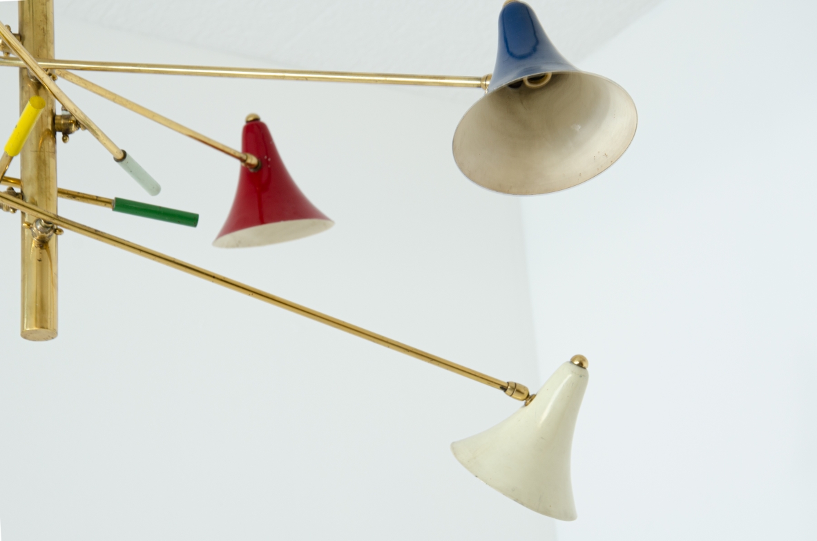 Rara lampada a sospensione con sei bracci in ottone orientabili e diffusori in metallo verniciato.  Manifattura italiana, anni '50.