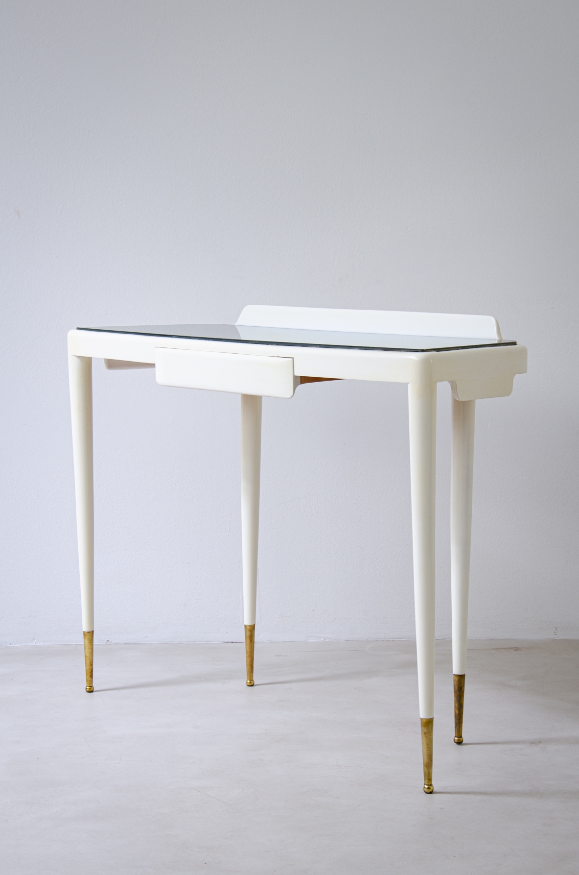 Console nello stile di Gio Ponti in legno laccato con piano in vetro opaline e puntali in ottone.  Manifattura italiana, 1940ca.