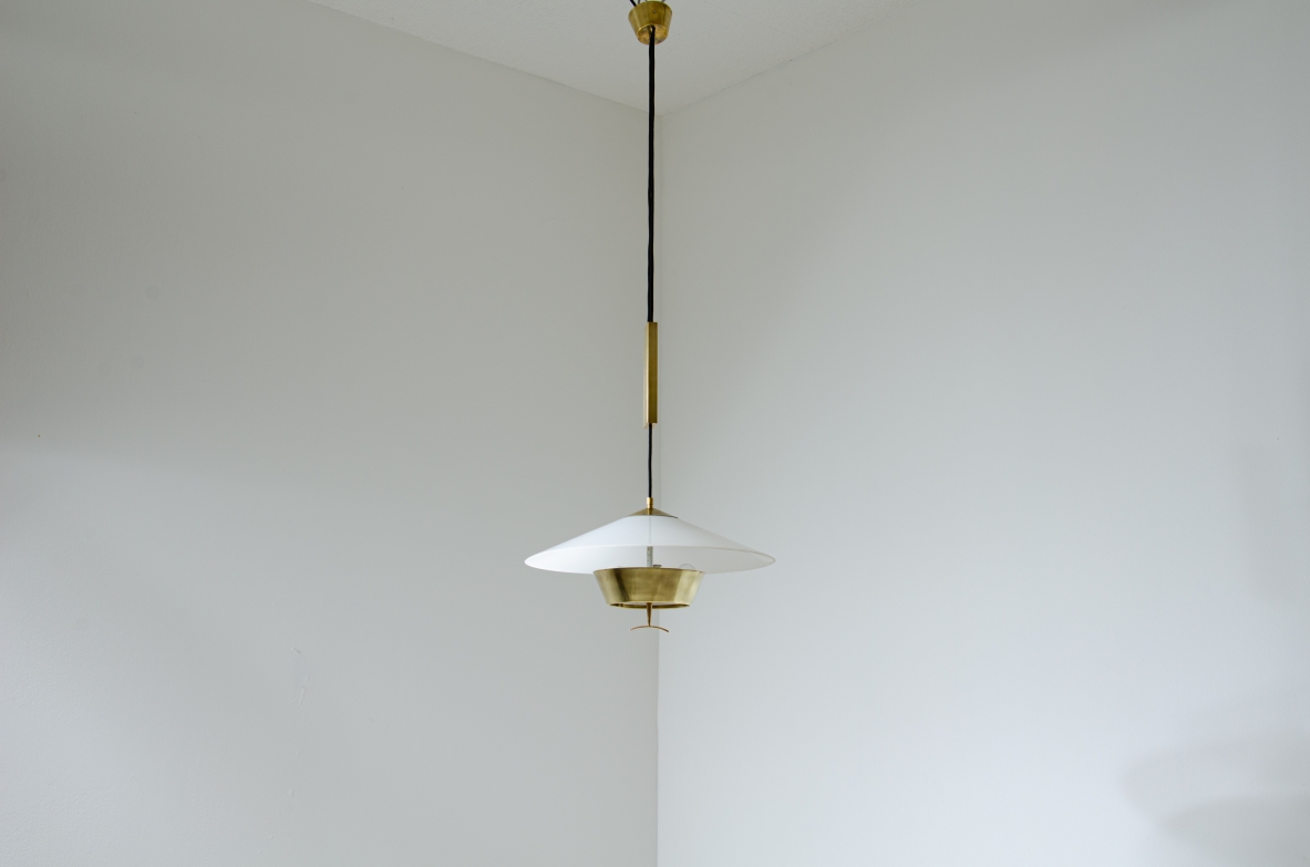 Stilnovo. Adjustable chandelier with brass counterweight, lampshade in perspex and brass. Manufactured in the late 60's.