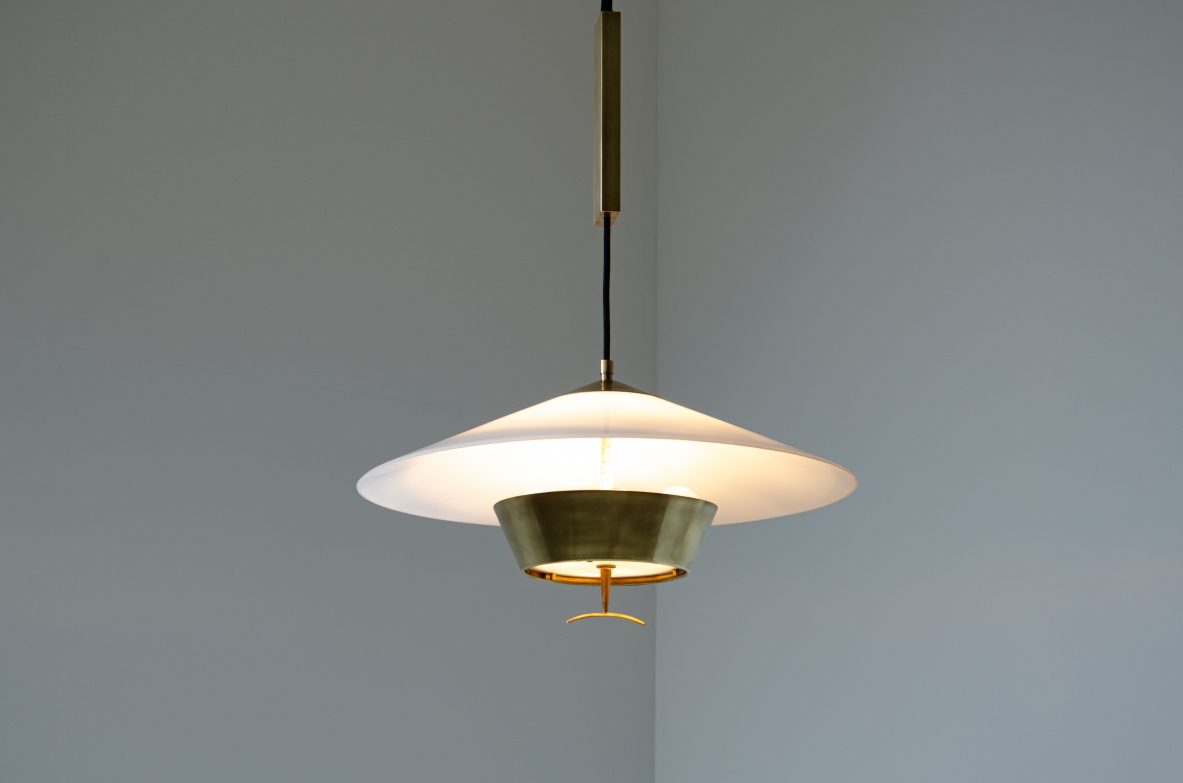 Stilnovo. Adjustable chandelier with brass counterweight, lampshade in perspex and brass. Manufactured in the late 60's.