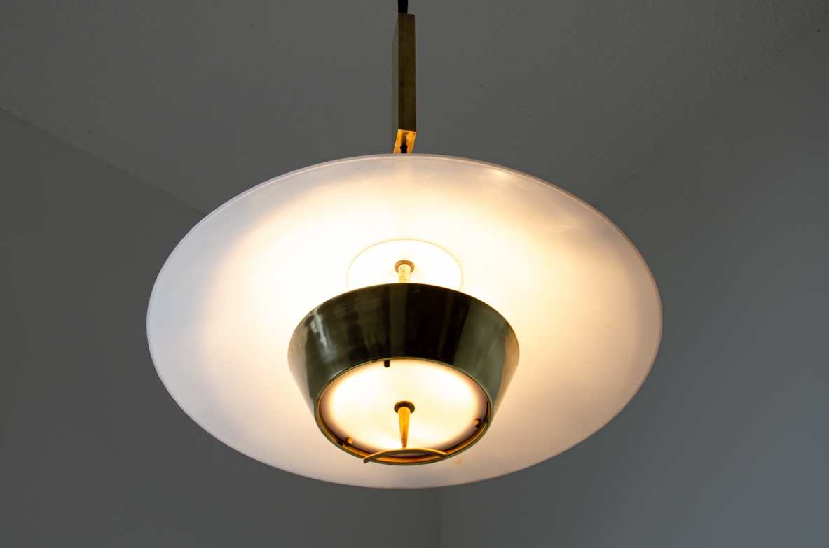 Stilnovo. Adjustable chandelier with brass counterweight, lampshade in perspex and brass. Manufactured in the late 60's.