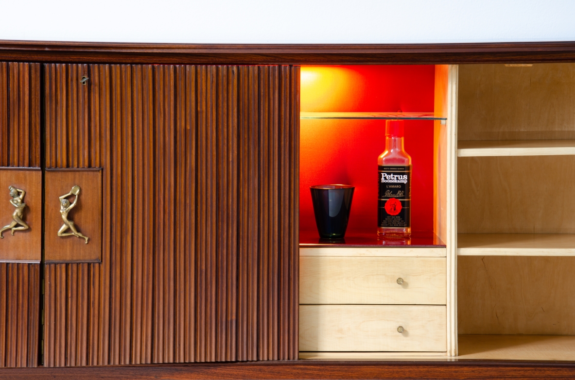 A large 1950's sideboard designed by Osvaldo Borsani for Arredamenti Borsani Varedo. Grinded mahogany, gilded bronze handles by Lucio Fontana, interior illumination.