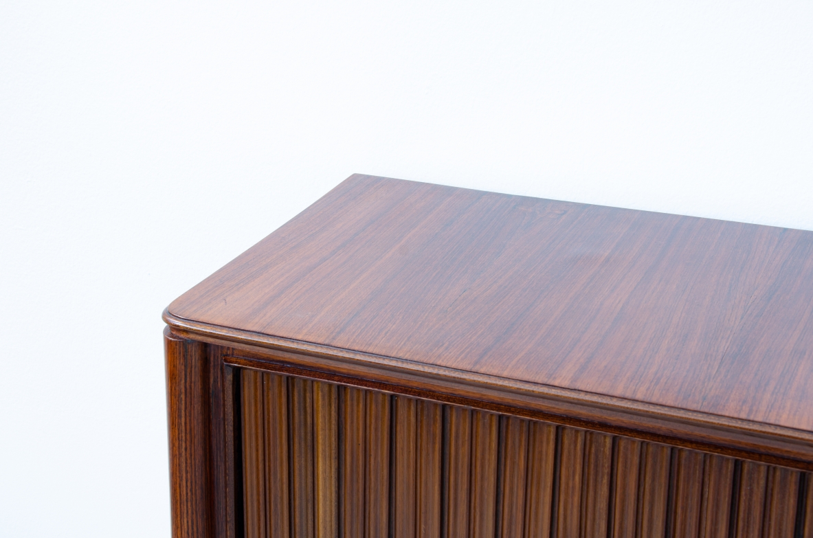 A large 1950's sideboard designed by Osvaldo Borsani for Arredamenti Borsani Varedo. Grinded mahogany, gilded bronze handles by Lucio Fontana, interior illumination.