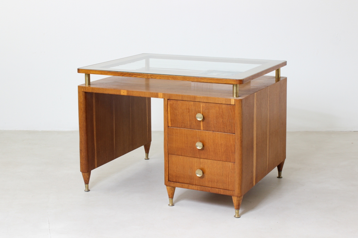 Writing table in oak wood with drawers on both sides, brass tips and crystal glass top.  Italian manufacture 1950's.