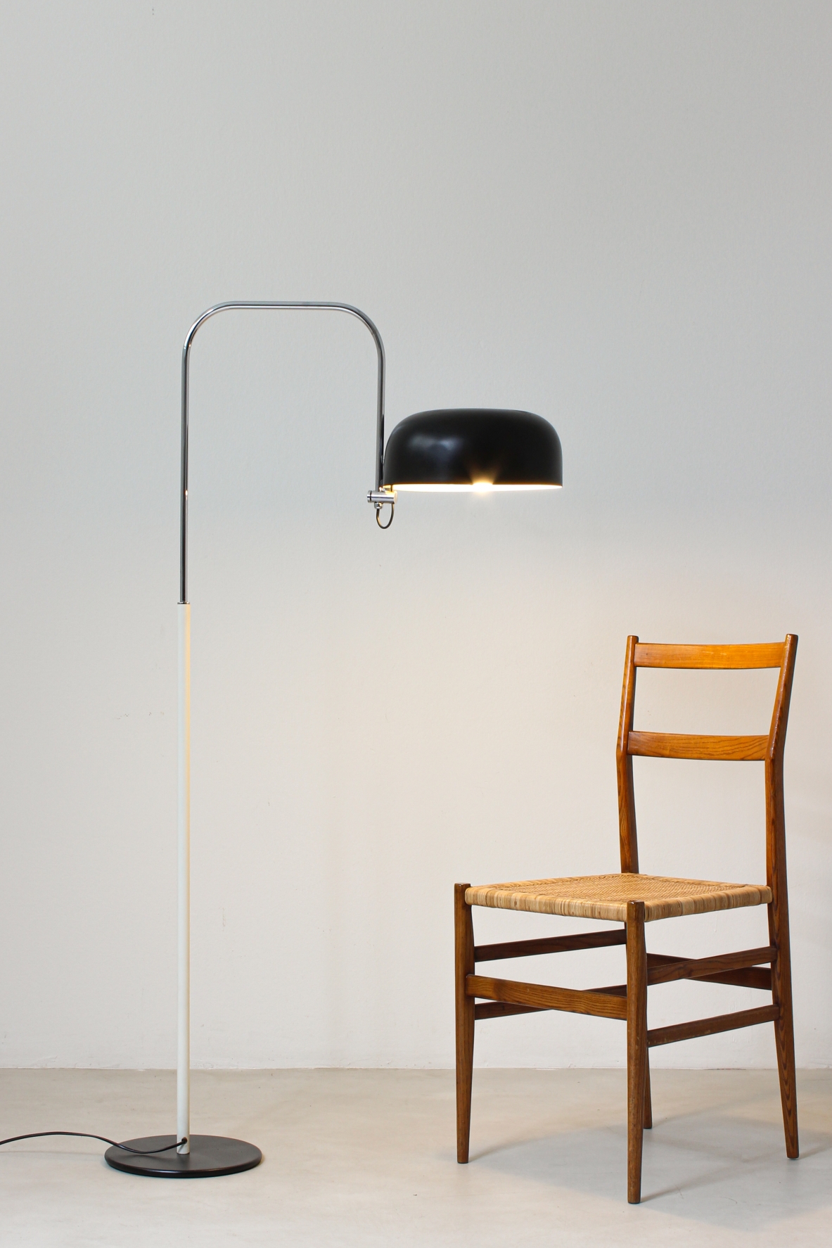 Lampada da lettura in metallo laccato bianco e nero con stelo curvato in metallo cromato.