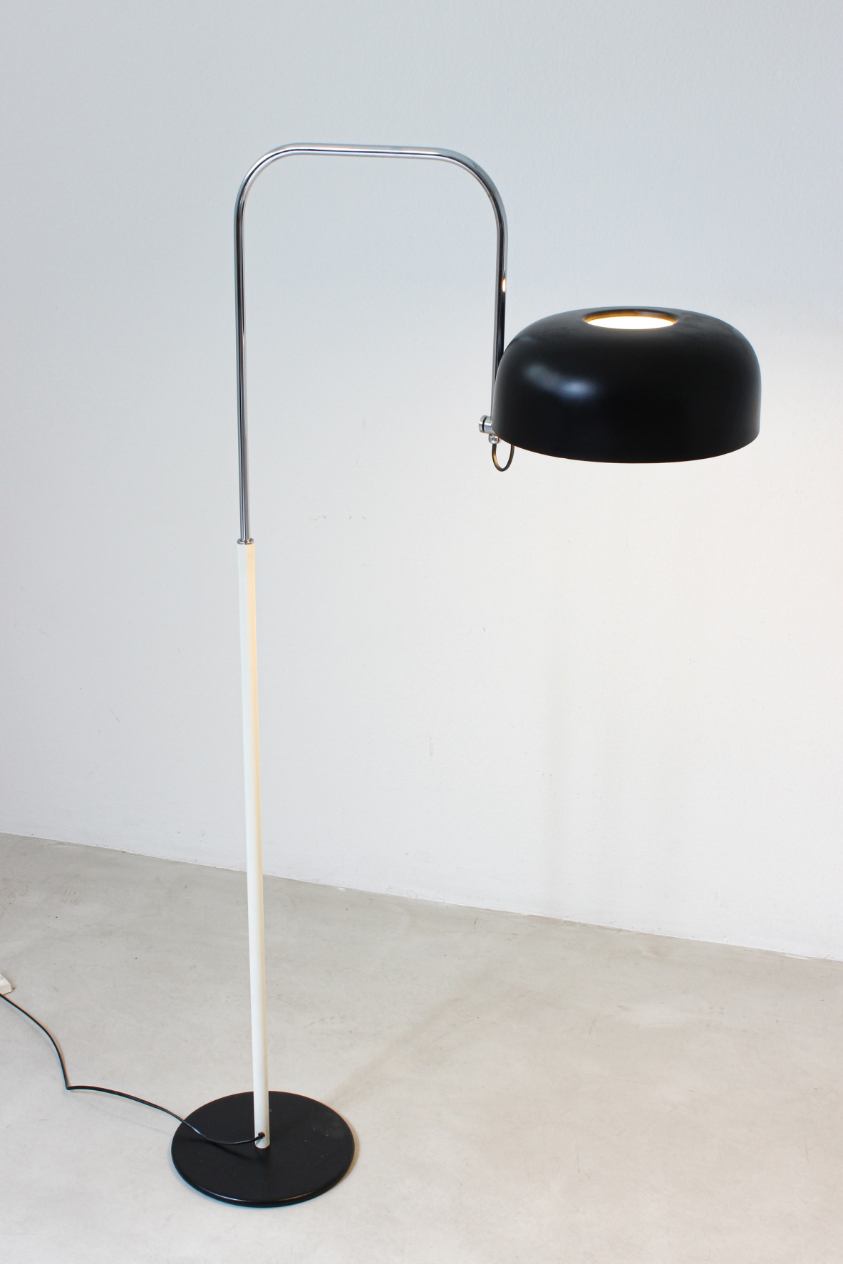 Lampada da lettura in metallo laccato bianco e nero con stelo curvato in metallo cromato.