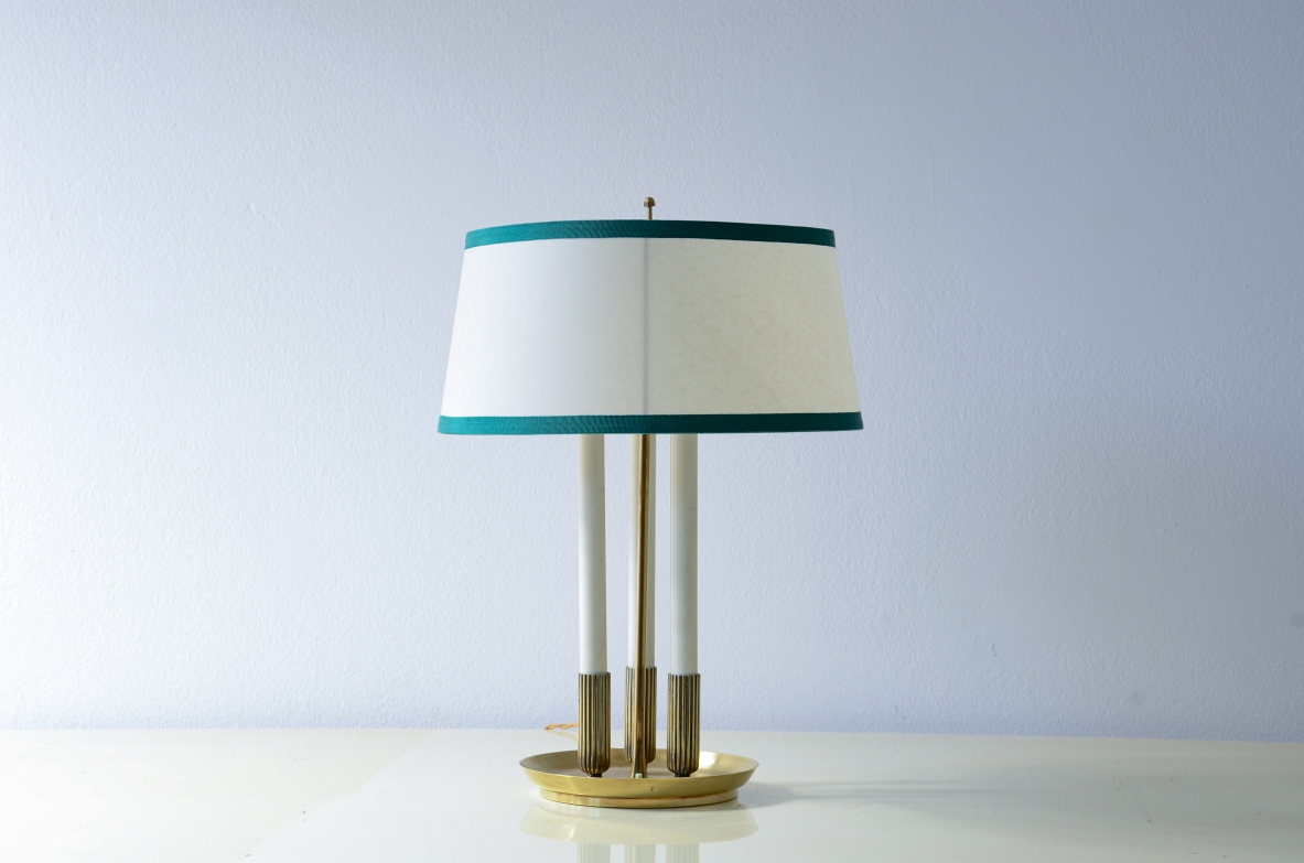 Lampada da tavolo con base tornita e stelo centrale in ottone, tre luci in metallo laccato e cappello in pergamena.  Manifattura italiana 1940ca.