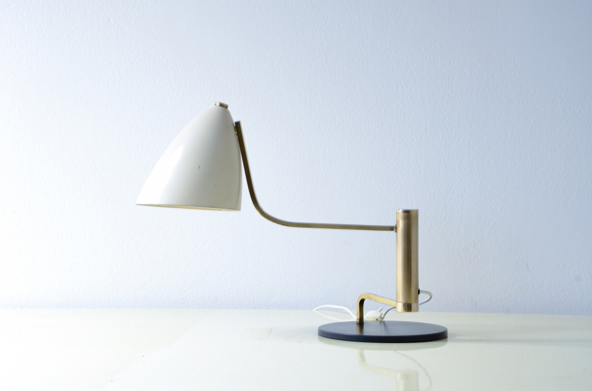 Lampada da tavolo in metallo e ottone con braccio snodabile in ottone e cappello in metallo verniciato.  Manifattura Italiana, 1950ca.