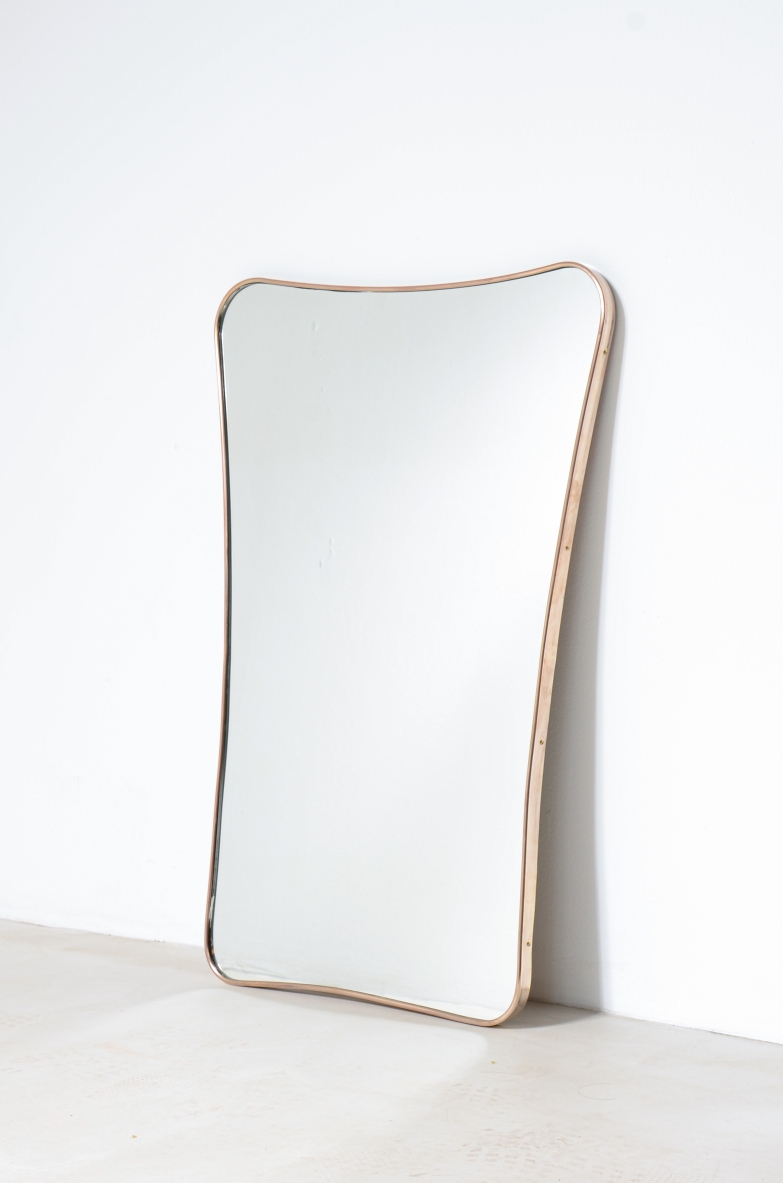 Elegante specchiera  con cornice in ottone sagomato.  Manifattura italiana, 1950ca.