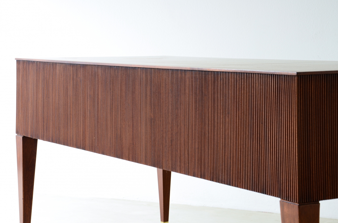 Scrivania in mogano a 4 cassetti con fronte e lati in legno grissinato,      gambe tronco piramidali con puntali in ottone.  Manifattura italiana anni 50'.
