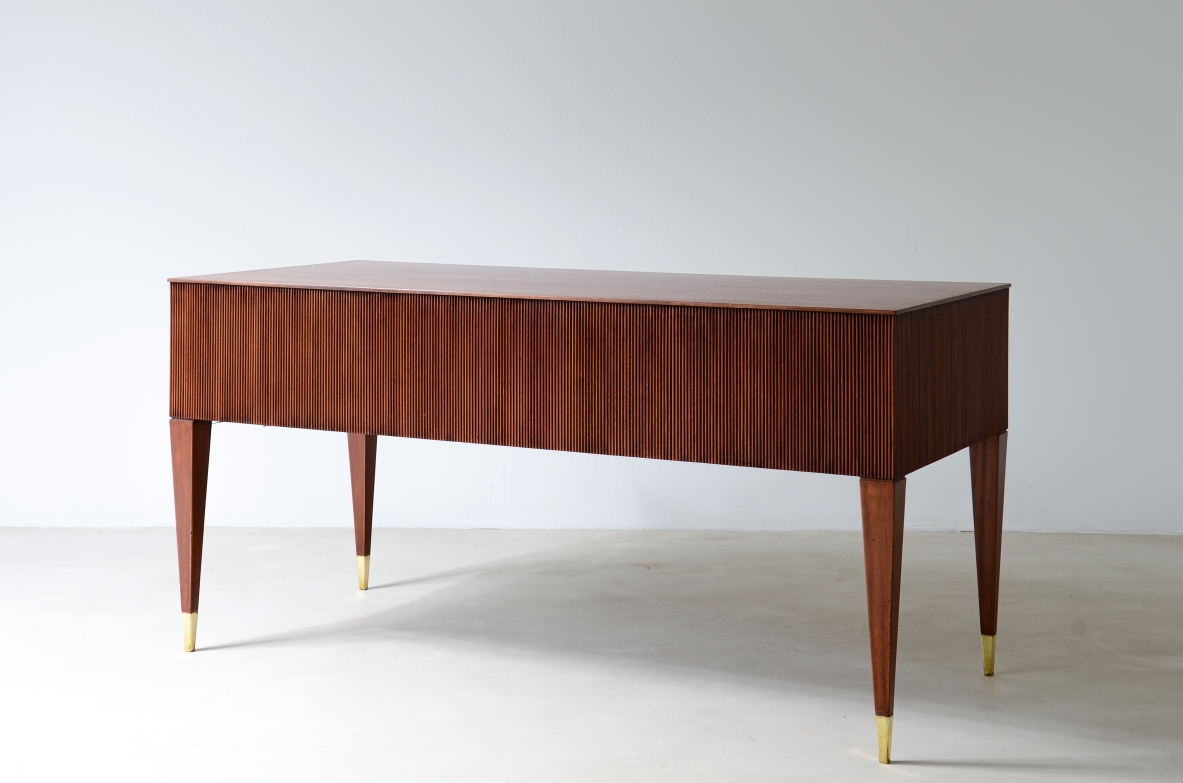 Scrivania in mogano a 4 cassetti con fronte e lati in legno grissinato,      gambe tronco piramidali con puntali in ottone.  Manifattura italiana anni 50'.