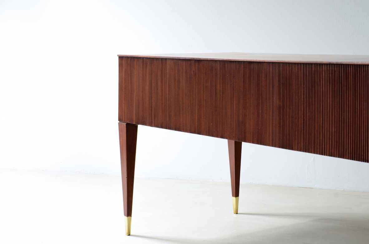 Scrivania in mogano a 4 cassetti con fronte e lati in legno grissinato,      gambe tronco piramidali con puntali in ottone.  Manifattura italiana anni 50'.
