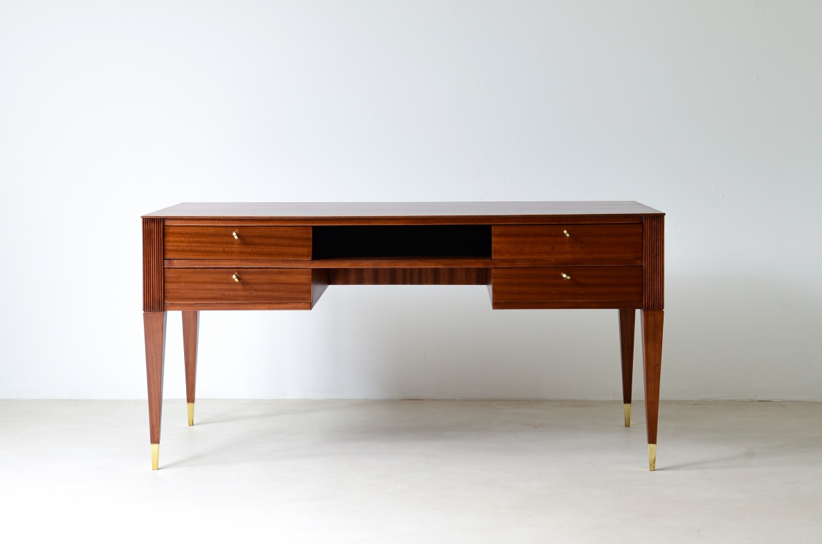 Scrivania in mogano a 4 cassetti con fronte e lati in legno grissinato,      gambe tronco piramidali con puntali in ottone.  Manifattura italiana anni 50'.