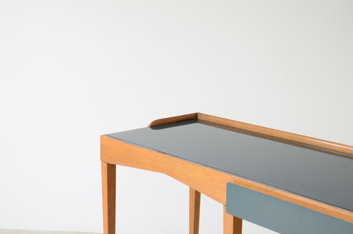 Refined oak writing desk with petrol green opaline glass top and backsplash.  Shaped drawer of the same color covered in polypropylene. Long thin legs with brass tips.  Attributed to Gio Ponti, early 1950s manufacture.