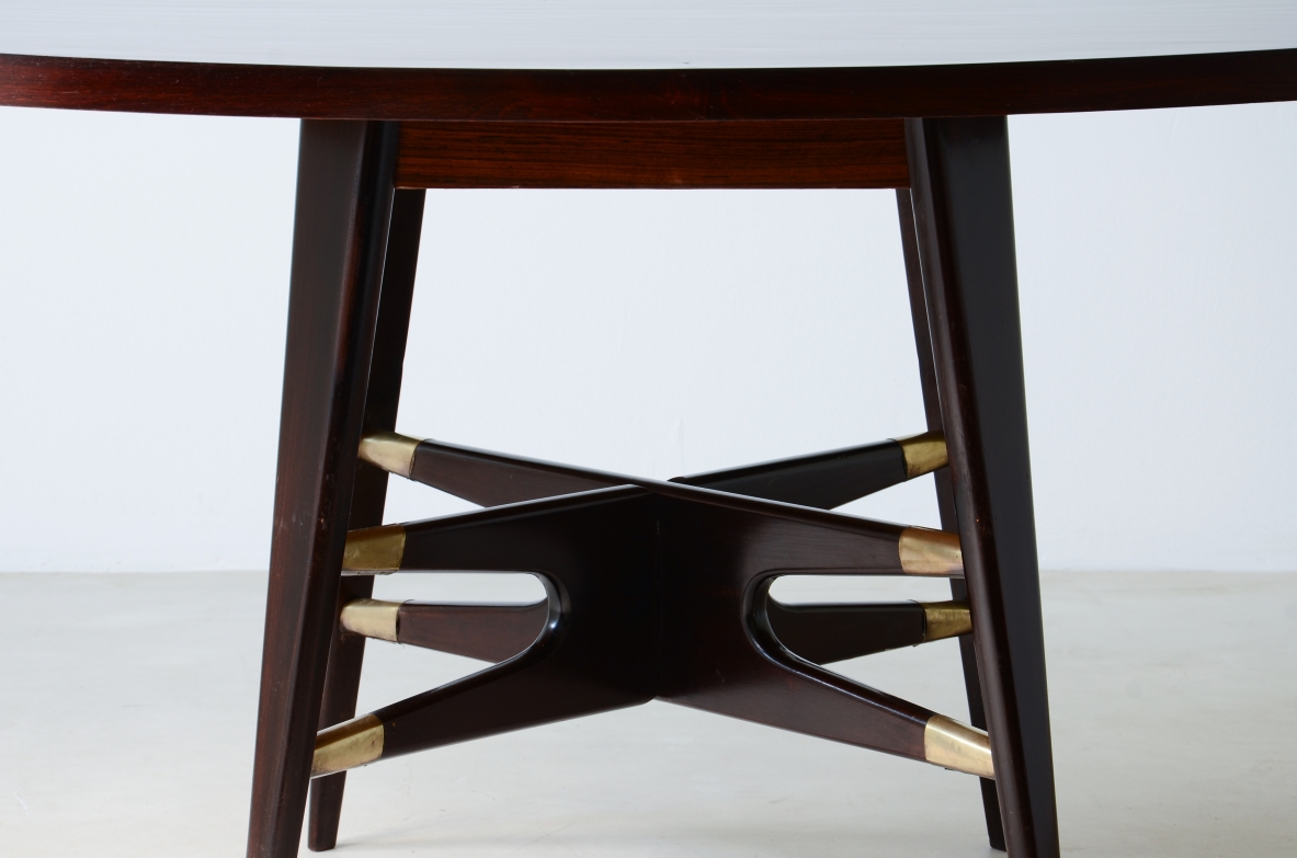 Gianni Vigorelli  Elegant oval table in stained wood with four-legged uprights and important cross with brass tips.  Italian manufacture, attr. Vigorelli. 1950 approx.