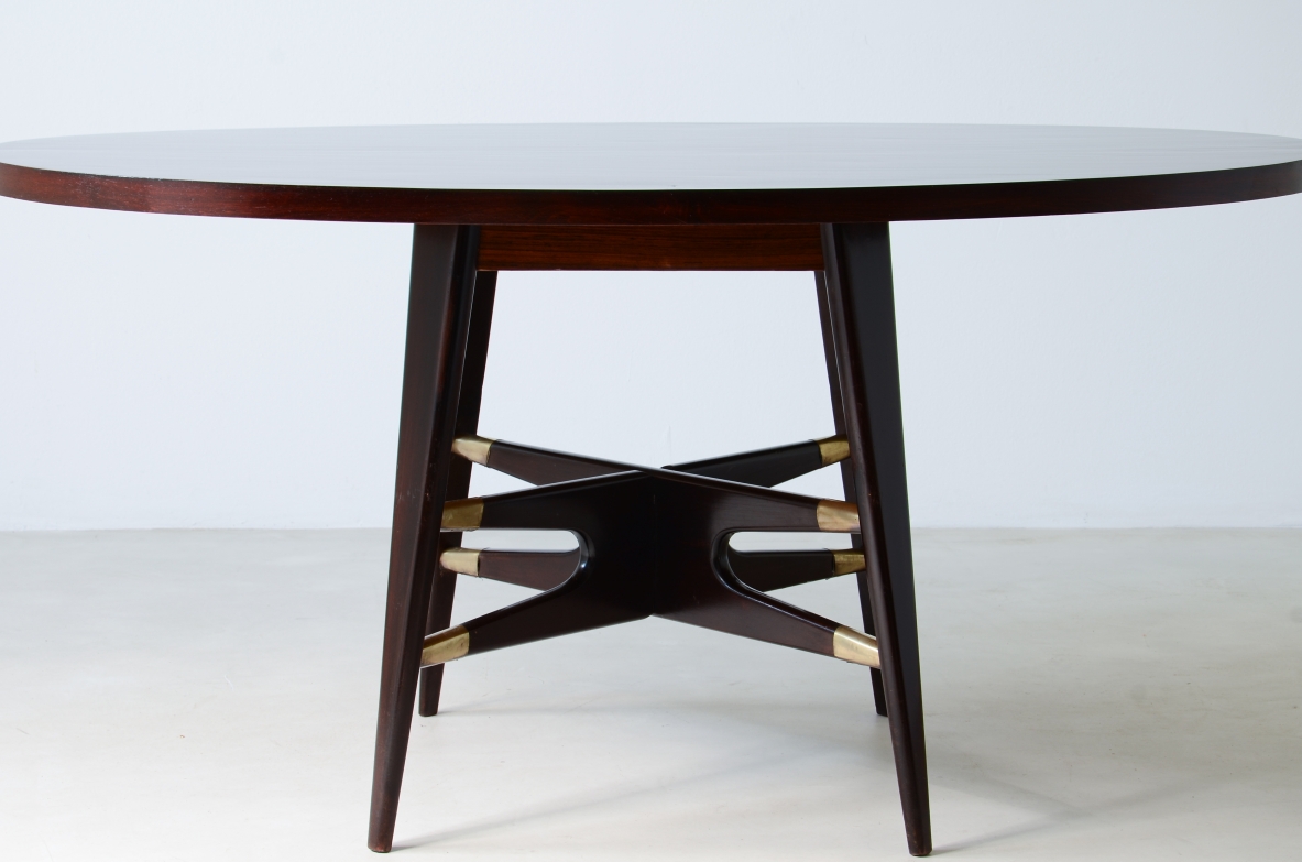 Gianni Vigorelli  Elegant oval table in stained wood with four-legged uprights and important cross with brass tips.  Italian manufacture, attr. Vigorelli. 1950 approx.