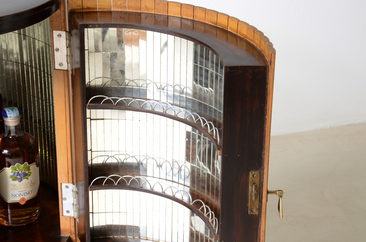 Small bar cabinet in the shape of a column in blond wood with a curved wooden base in the style of Ico Parisi.  Italian manufacture, ca. 1950.