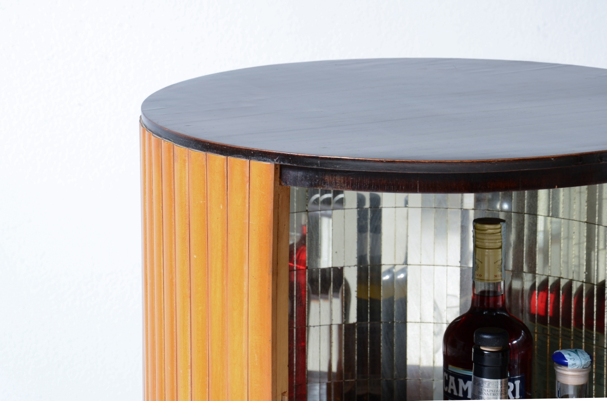 Small bar cabinet in the shape of a column in blond wood with a curved wooden base in the style of Ico Parisi.  Italian manufacture, ca. 1950.