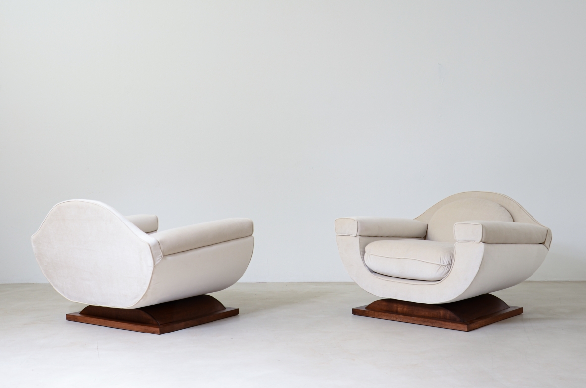 Coppia di grandi poltrone dalla forma organica con basamento in legno, rivestite in velluto cotone.  Manifattura italiana anni '60
