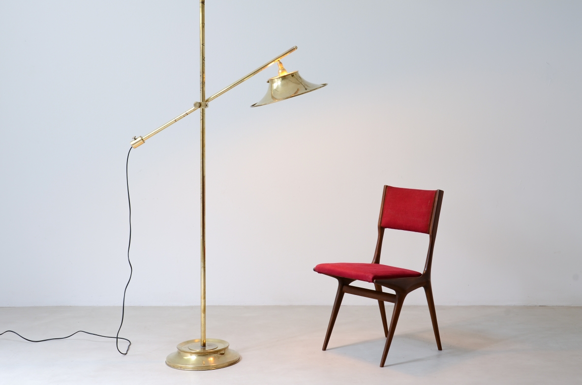 Lampada da terra in ottone con asta a bilanciere, base e cappello in ottone sagomato e forato.  Manifattura italiana, 1950ca.