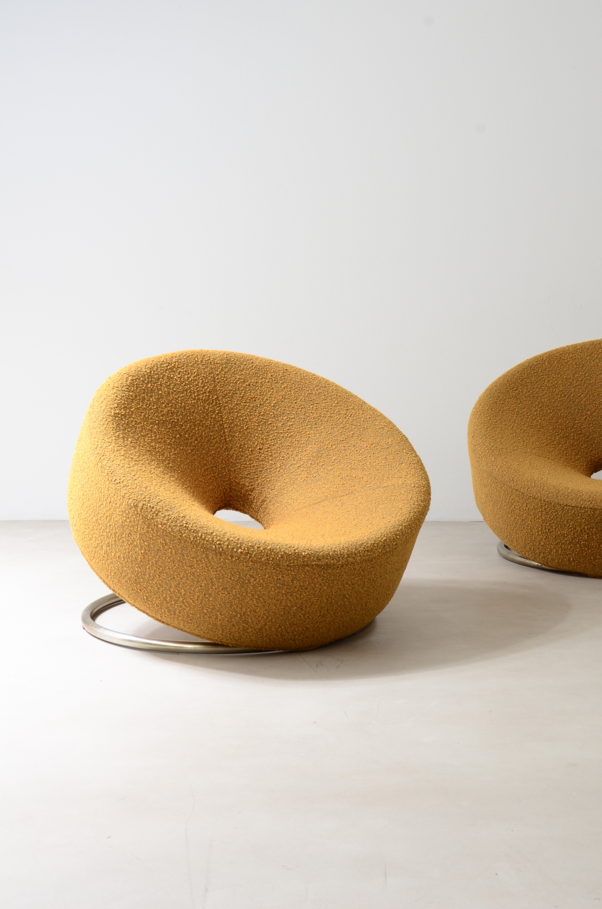 Coppia di poltrone a ciambella con base in acciaio e rivestimento tessile.  Manifattura italiana anni '70