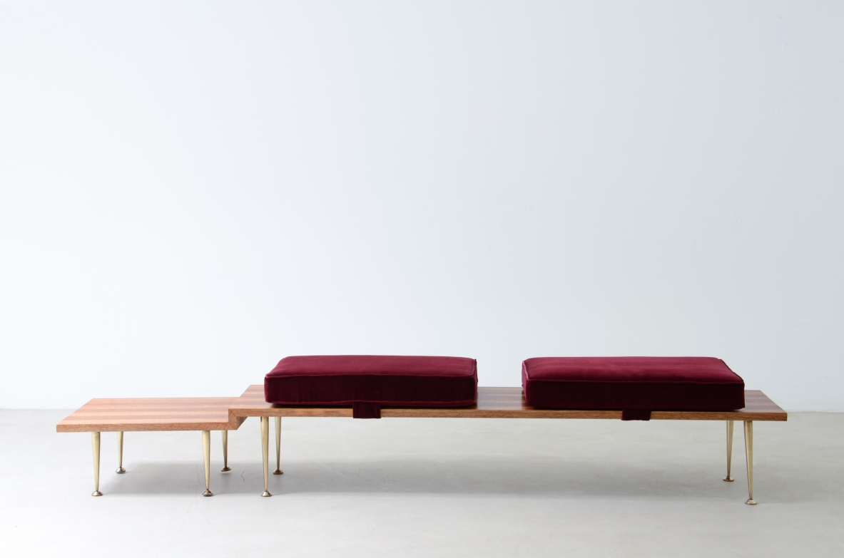 Large shaped wooden bench with eight turned brass feet and velvet-covered cushions.  Italian manufacture from the 1950s