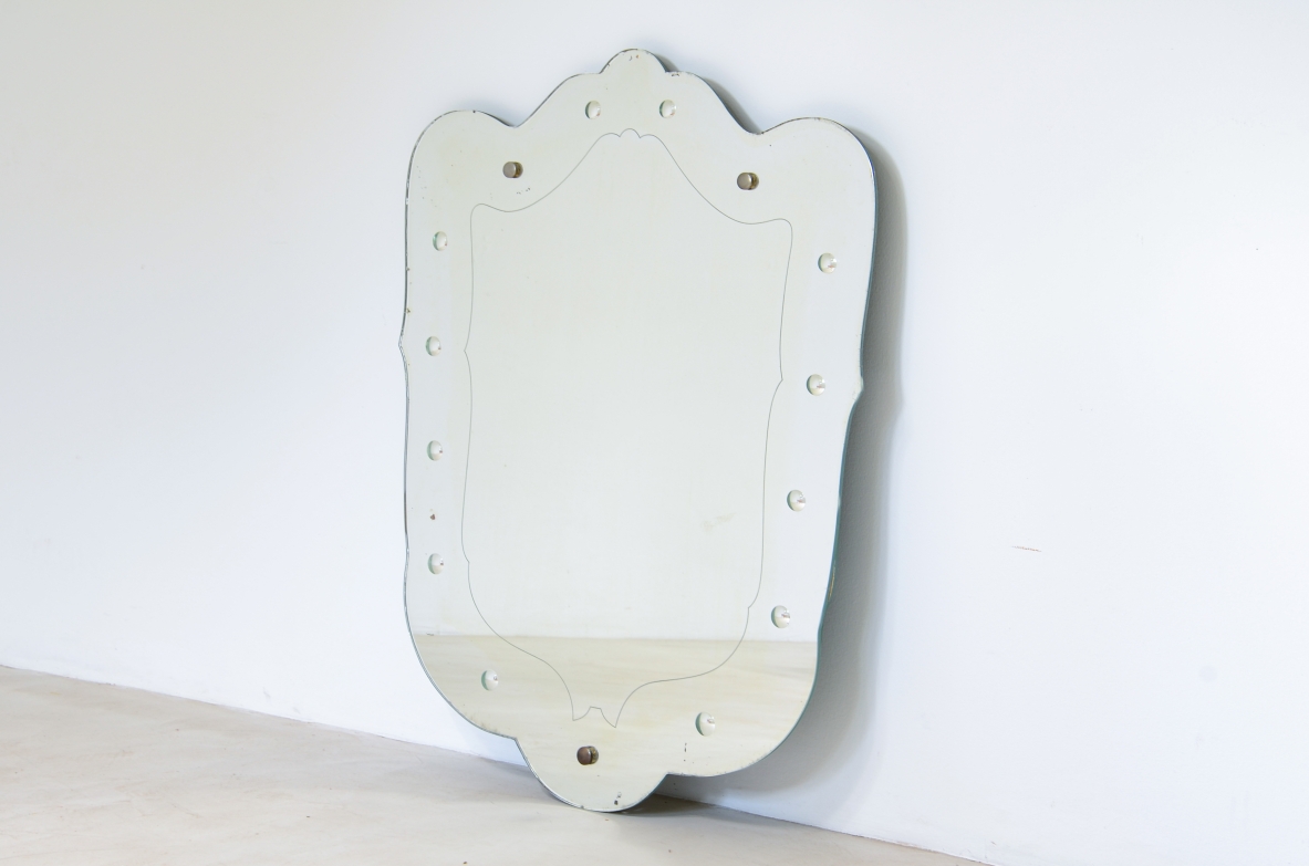 Specchiera sagomata con decoro a bottoni retro incisi.  Manifattura italiana anni 40ca.