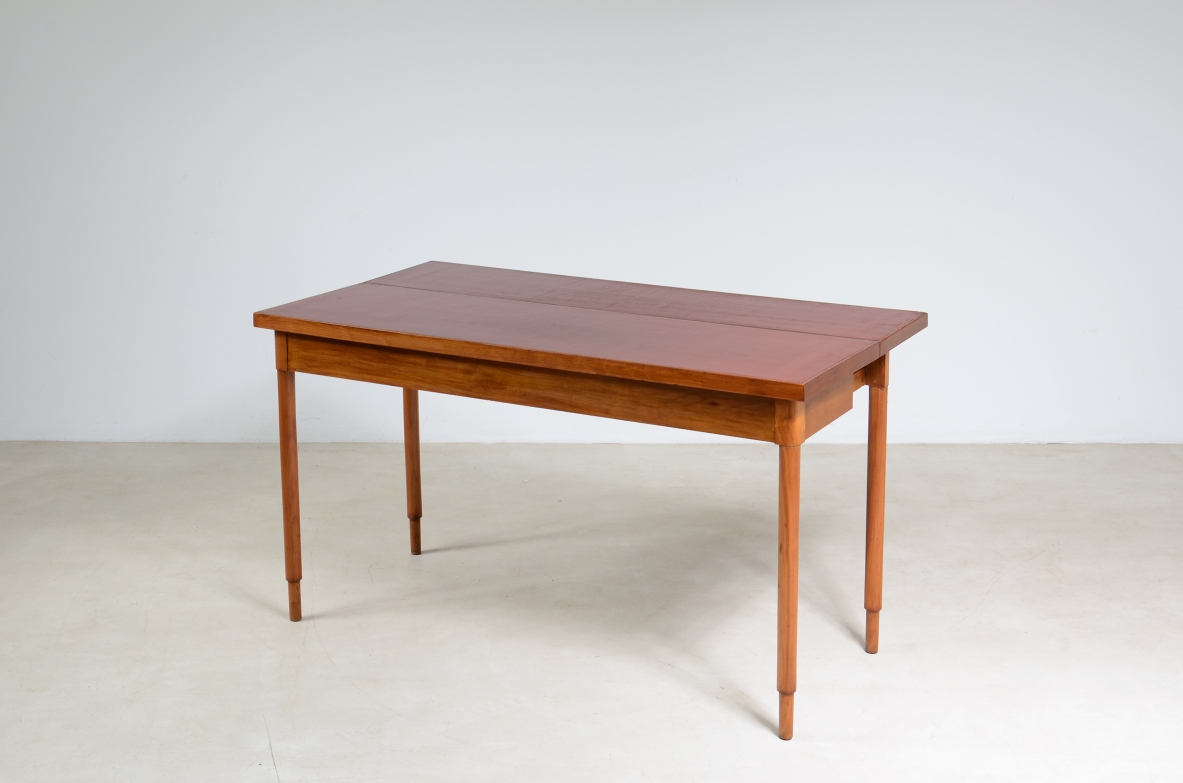 Tavolo console in noce con piano laccato rosso.