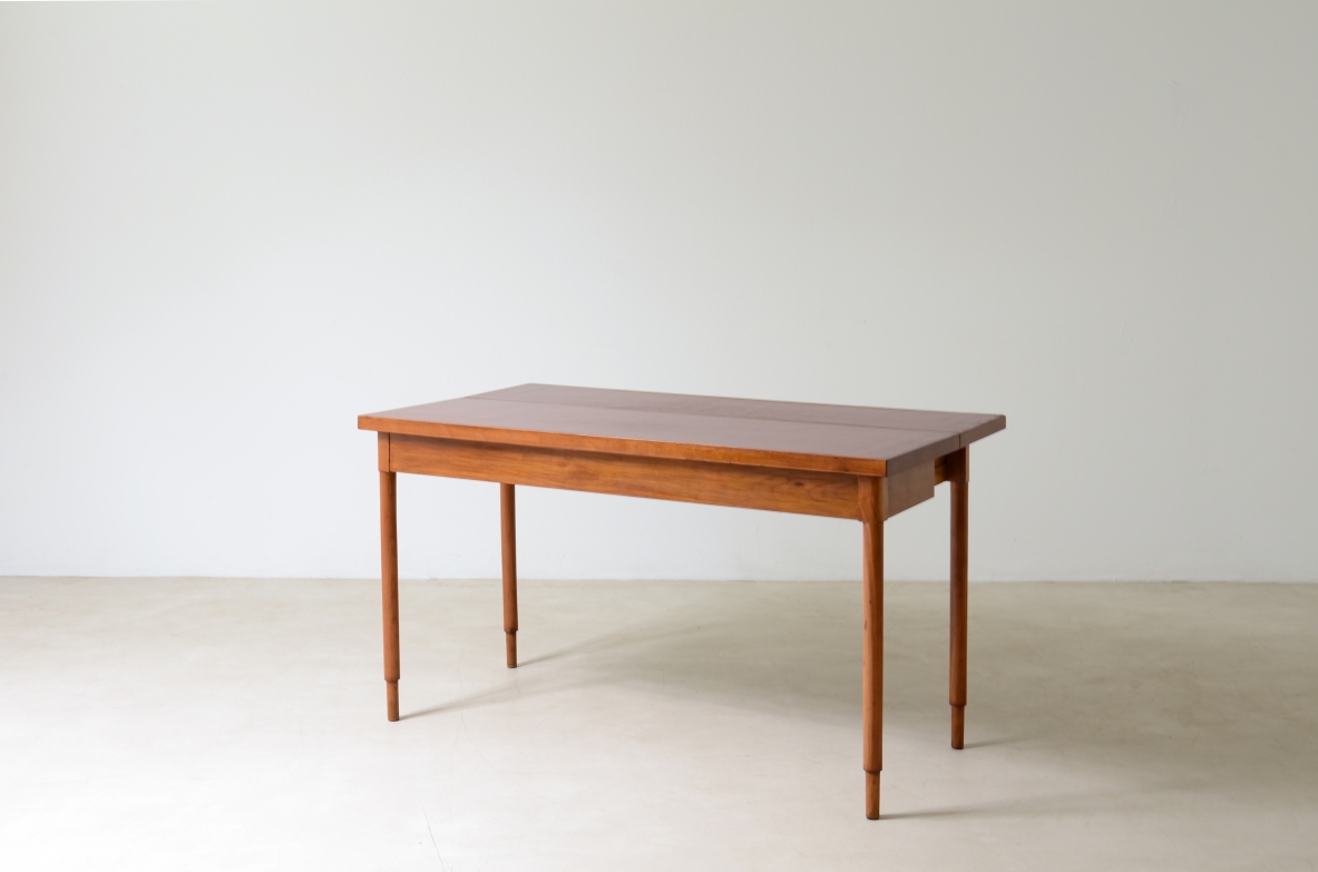 Tavolo console in noce con piano laccato rosso.