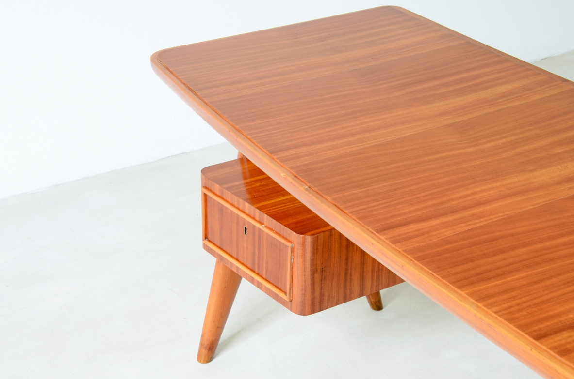 Small walnut desk with two drawers and storage compartment.1950