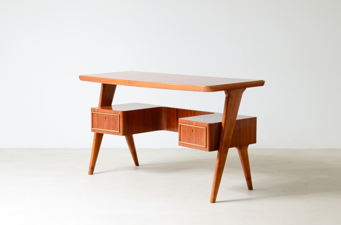 Small walnut desk with two drawers and storage compartment.1950