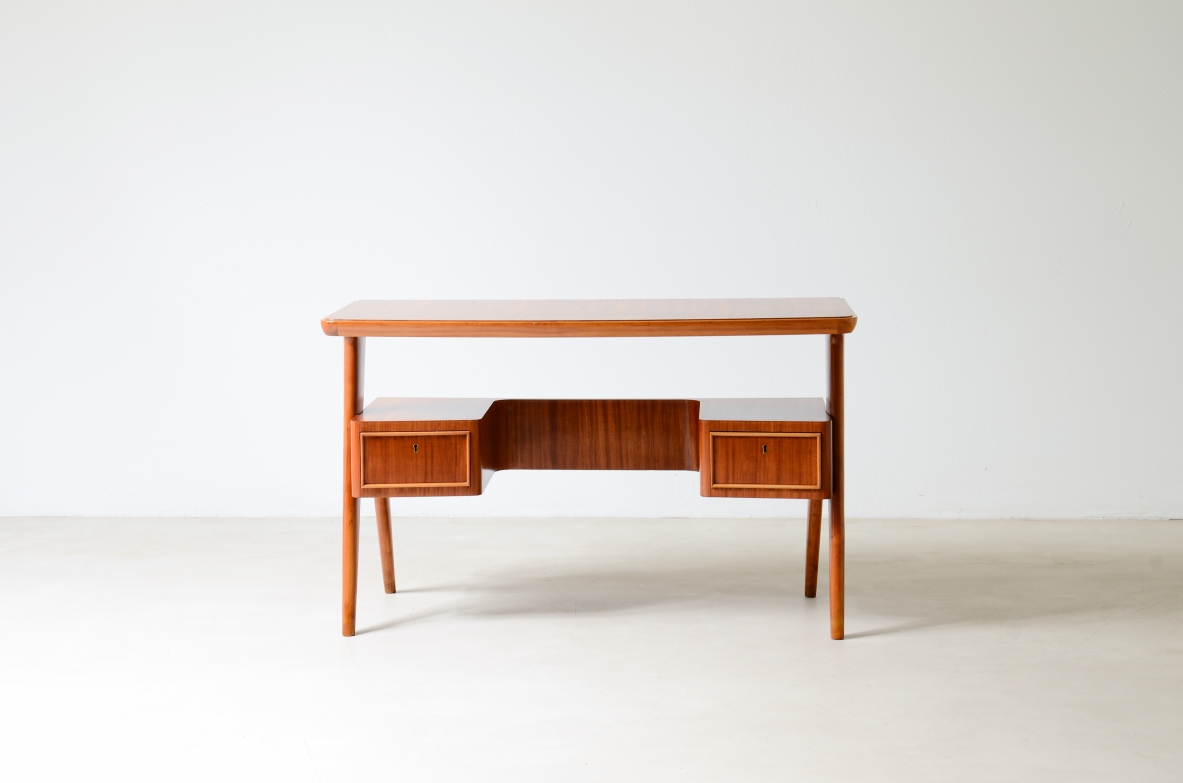 Small walnut desk with two drawers and storage compartment.1950