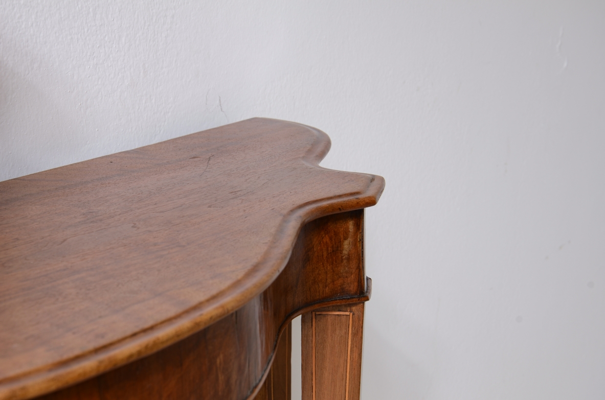 Small console in walnut with shaped top and thin tapered legs.1850