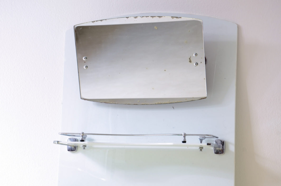 Specchio da bagno in opaline bianca con specchio basculante, mensola e porta saponette in metallo cromato.  Manifattura francese, 1930ca.