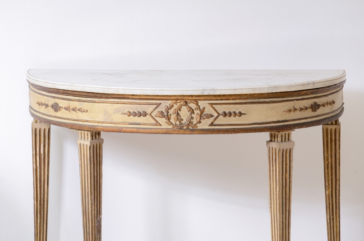 Pair of elegant half-moon console tables in lacquered and gilded wood, Louis XVI period, ca. 1770.