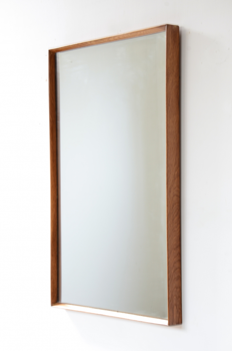 Two mirrors with shaped wooden frames.