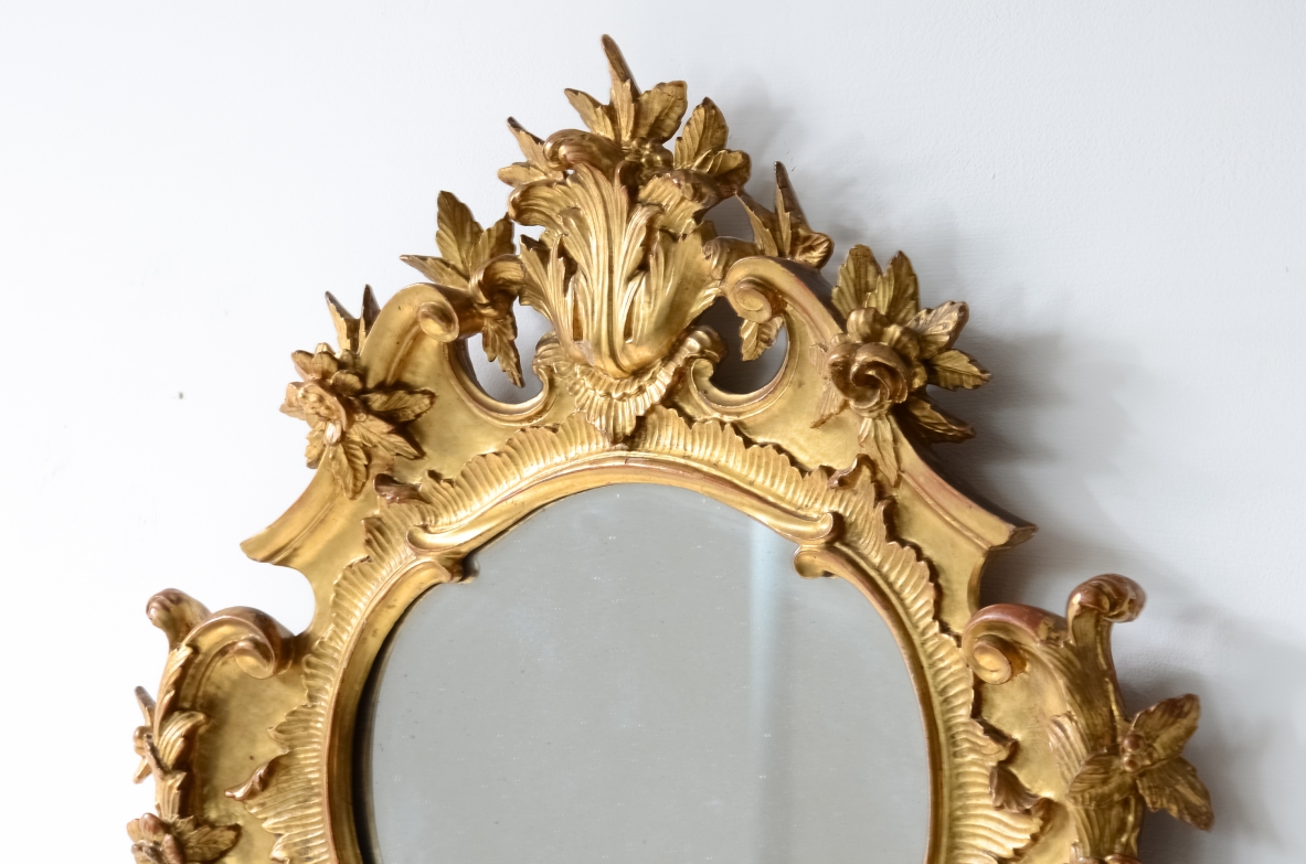 Piccola straordinaria specchiera in legno dorato con intaglio a 